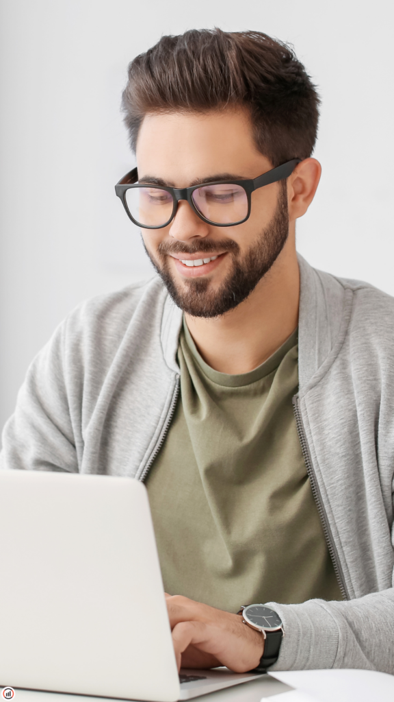 image d'un homme portant des lunettes et la barbe souriant sur un ordinateur portable blanc